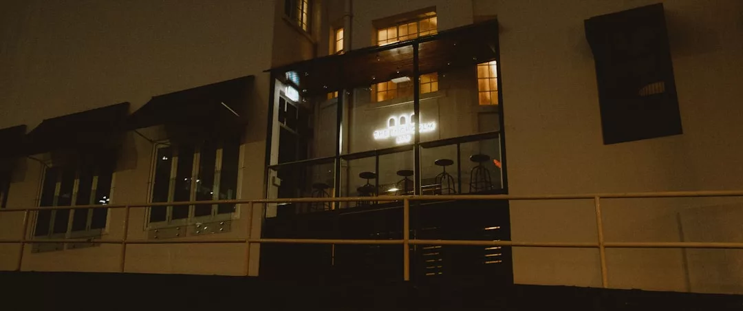 Dimly lit cafe at night with glass doors, empty chairs, and a glowing sign reading “radio galileo,” nestled in Palma de Mallorca’s streets—where whispers of market insights drift through the quiet ambiance.