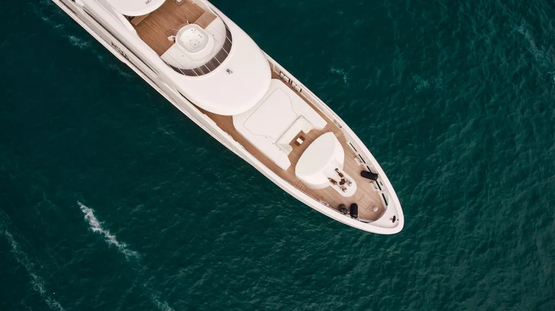 Aerial view of a white luxury yacht sailing on deep blue ocean water, perfect for memorable outings and ski-boat adventures in Palma Bay.