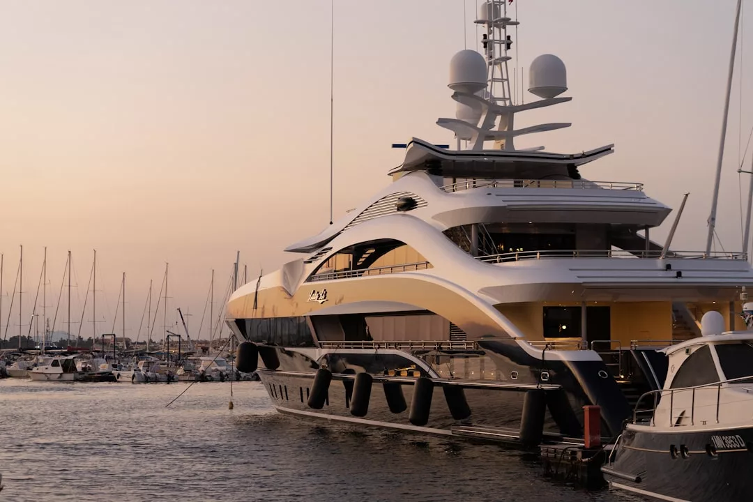 A large luxury yacht docked at Palma Harbor during sunset, with sailboats in the background—a perfect scene that captures the essence of the Yacht lifestyle.
